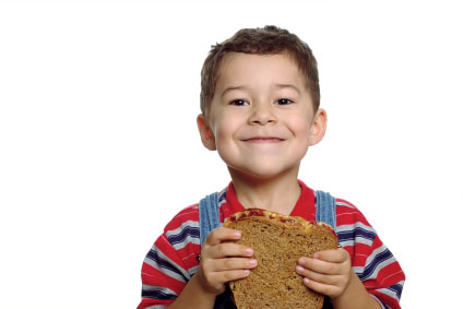 Cute boy ready to eat a peanut butter and jelly sandwich on whole wheat bread